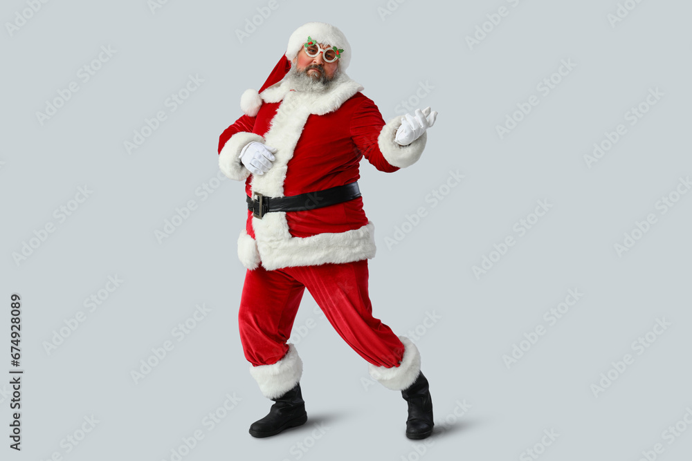 Funny Santa Claus dancing on grey background Funny Santa Claus dancing on grey background