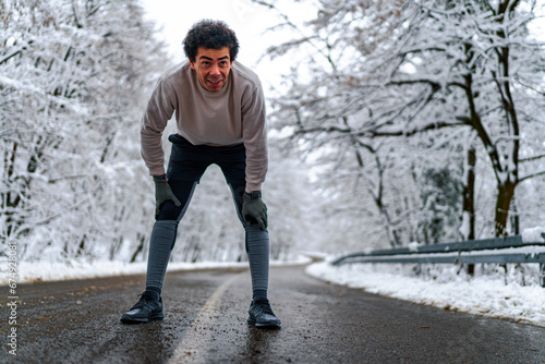 Man looking at his phone and sending text massages, there's snow covered scenery in the background © DusanJelicic