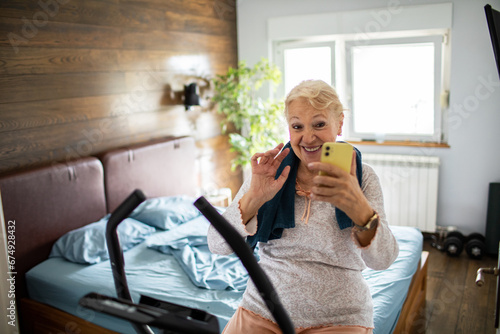Senior woman having video call after workout at home