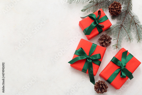 Christmas gift boxes with fir branches and cones on white background