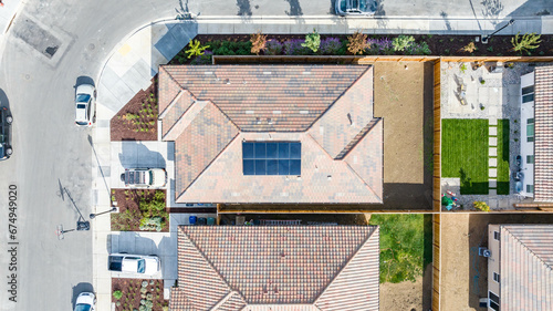 Top Down view of a house with a solar panel on it and a empty backyard photo