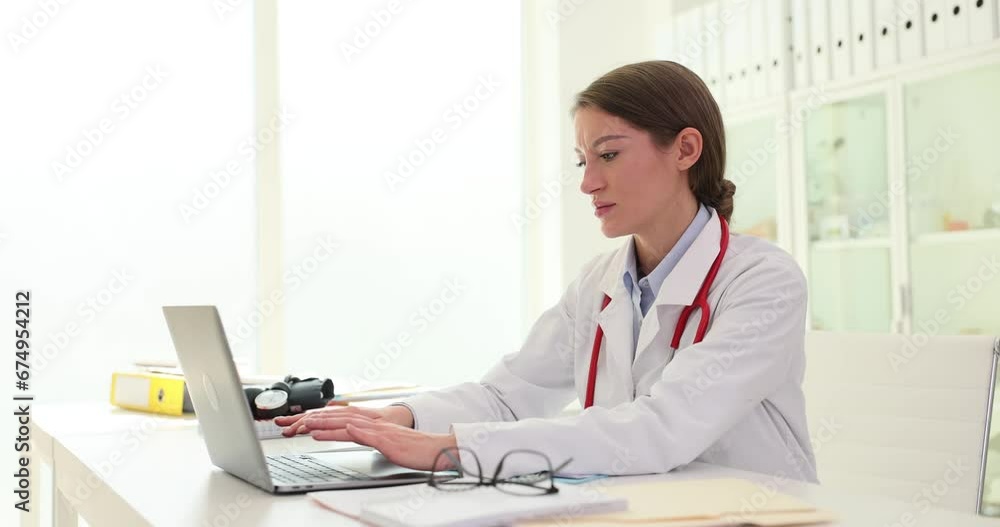 Serious young female doctor using laptop computer for remote medical consultation Serious young female doctor using laptop computer for remote medical consultation