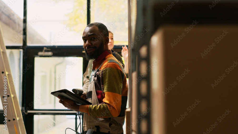 Employees team using scanner and tablet in storage room to check barcodes on merchandise stored in packages. Young worker examining cargo products on racks and shelves, stock inventory.