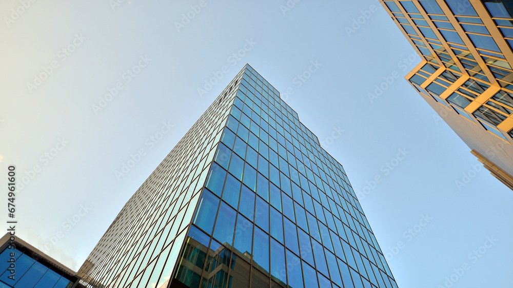 Looking up blue modern office building. The glass windows of building with  aluminum framework. - obrazy, fototapety, plakaty 