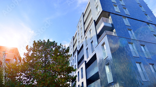 Modern residential area. Trees near the new apartment building. Nature friendly luxury real estate.