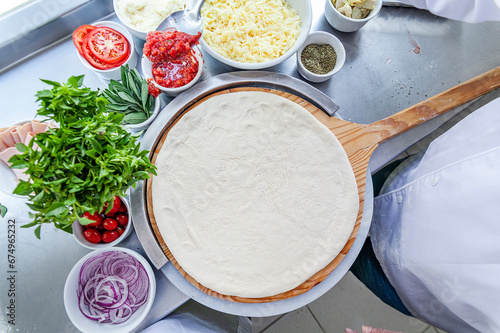 Making pizza bench top view spreading pizza dough