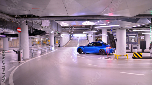 Underground parking under shopping center. Car parking garage with lighting and columns. photo