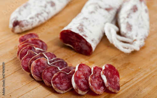 Spanish sausage fuet on a wooden table, closeup