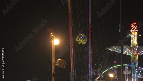 This video shows a fair gyroscope slingshot ride at night. photo