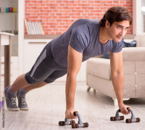 Young handsome man doing sport exercises at home