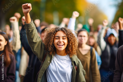 Young female student standing in determined solidarity, with a group of people actively protesting in a movement. Concept of fighting for change and embodying Gen Z spirit photo