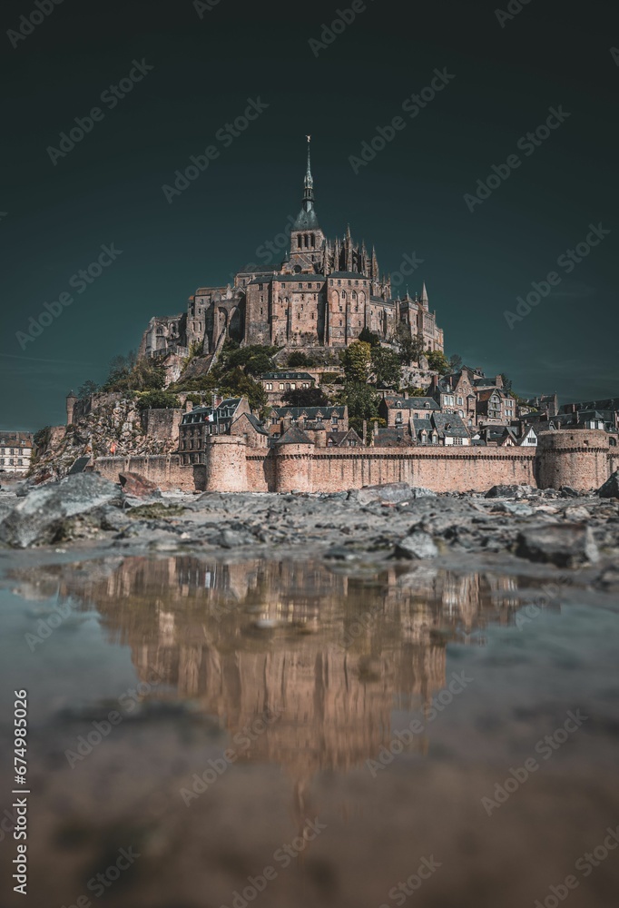 Fototapeta premium Picturesque view of Mont Saint Michel, an island commune in France, from the banks of the river