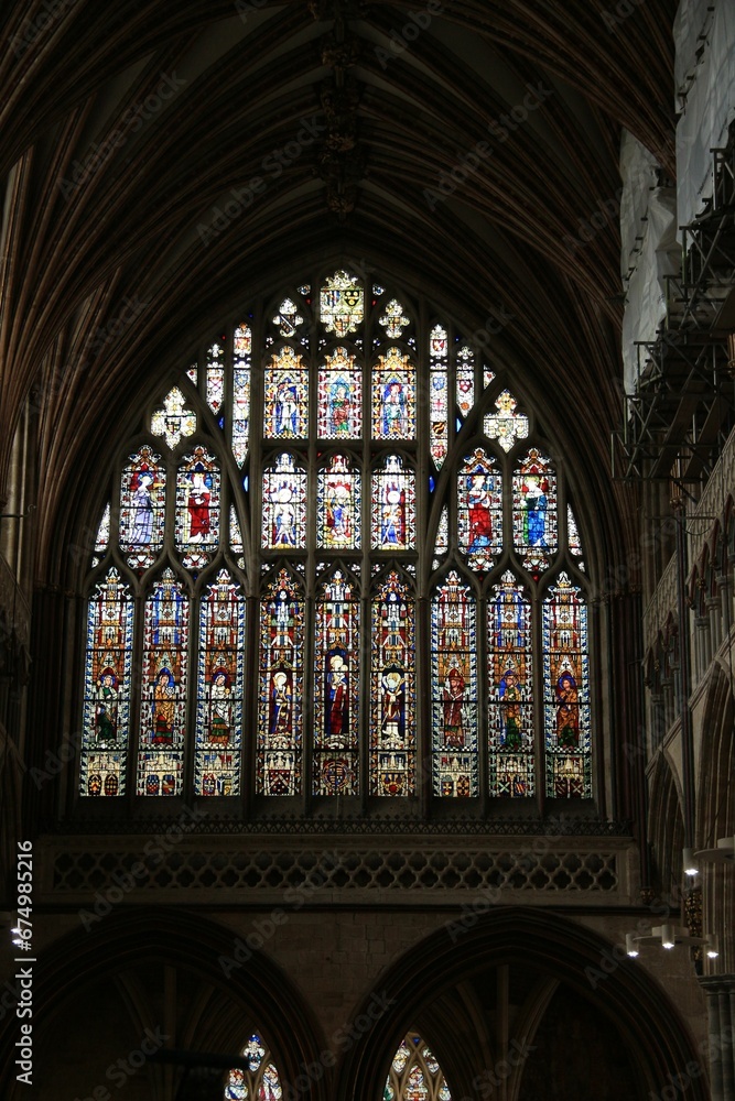 Aged church with an intricate stained glass window in Exeter Cathedral