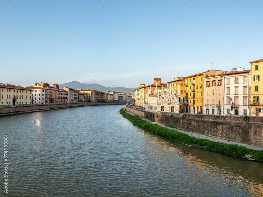 Idyllic riverside view featuring a tranquil body of water surrounded by buildings in Parma, Italy.