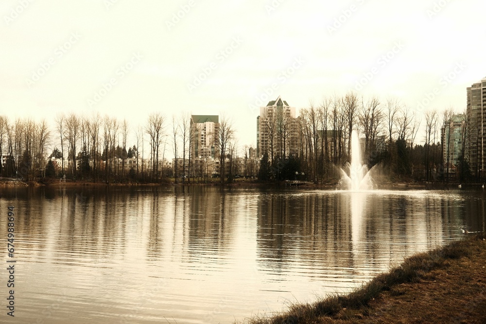 Outdoor water feature in a lake setting with a cityscape visible in the background