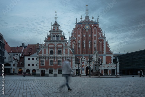 Blurred silhouette of a person walking near the House of the Blackheads in Riga, Latvia