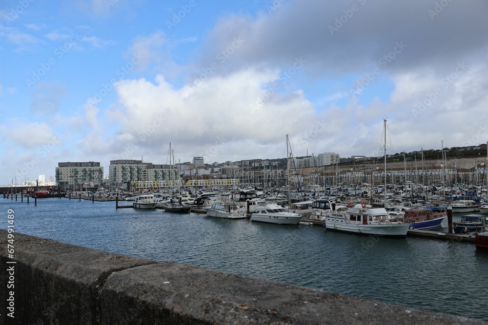 Scenic view of boats moored at a harbor on a cloudy day