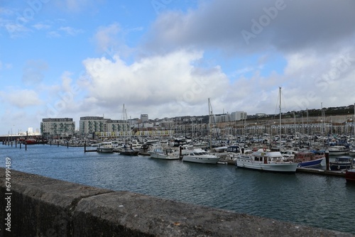 Scenic view of boats moored at a harbor on a cloudy day © Wirestock