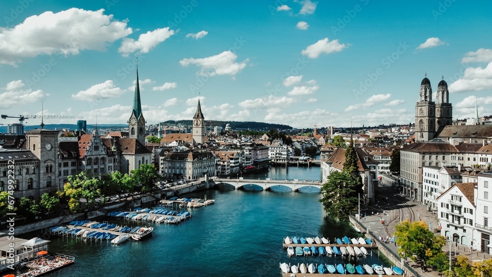 Scenic view of a riverbank with multiple sailboats and motorboats in the waters in Zurich - obrazy, fototapety, plakaty 