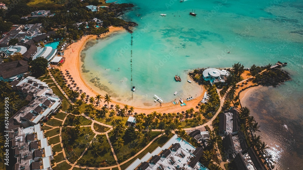 Scenic aerial view of a beach with green palm trees and hotels. Resort in Mauritius.
