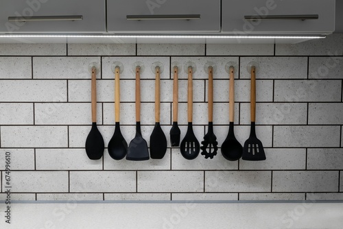 Closeup of a collection of silicon kitchenware hanging on a wall photo