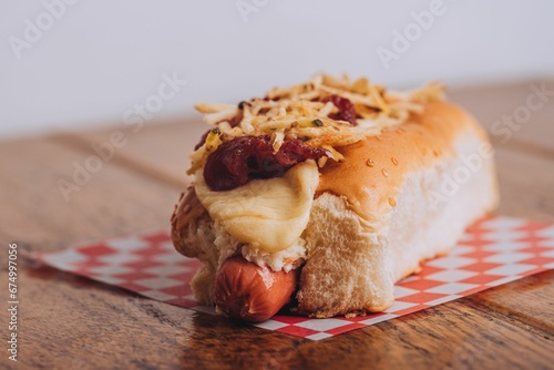 Delicious and juicy hot dog served on a soft and lightly toasted bun on a wooden table. photo