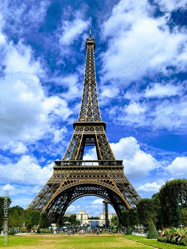 Iconic Eiffel Tower in Paris, France, against a blue cloudy background.