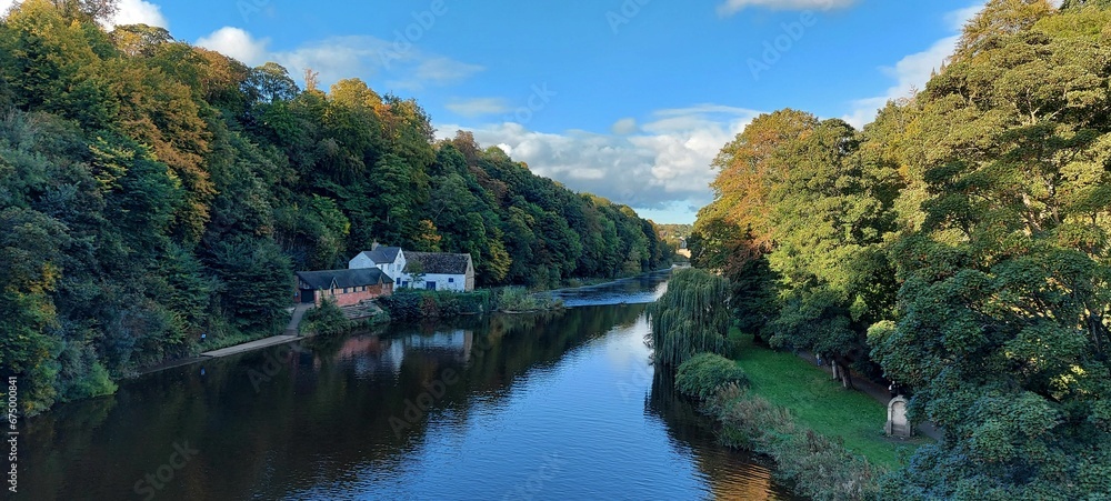 Tranquil scene of a park featuring a scenic waterway and lush foliage. Tranquil scene of a park featuring a scenic waterway and lush foliage.