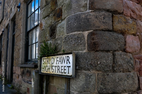 Image of a street sign on the corner of a building, showing the name of the High Street(Stryd Fawr)