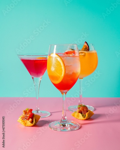 Vertical of three glasses of cocktail on a vibrant background