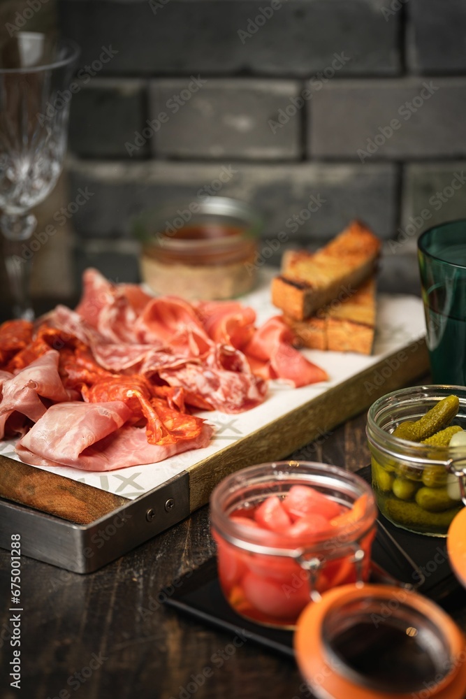 Vertical of a plate of freshly sliced meat on a wooden board Vertical of a plate of freshly sliced meat on a wooden board