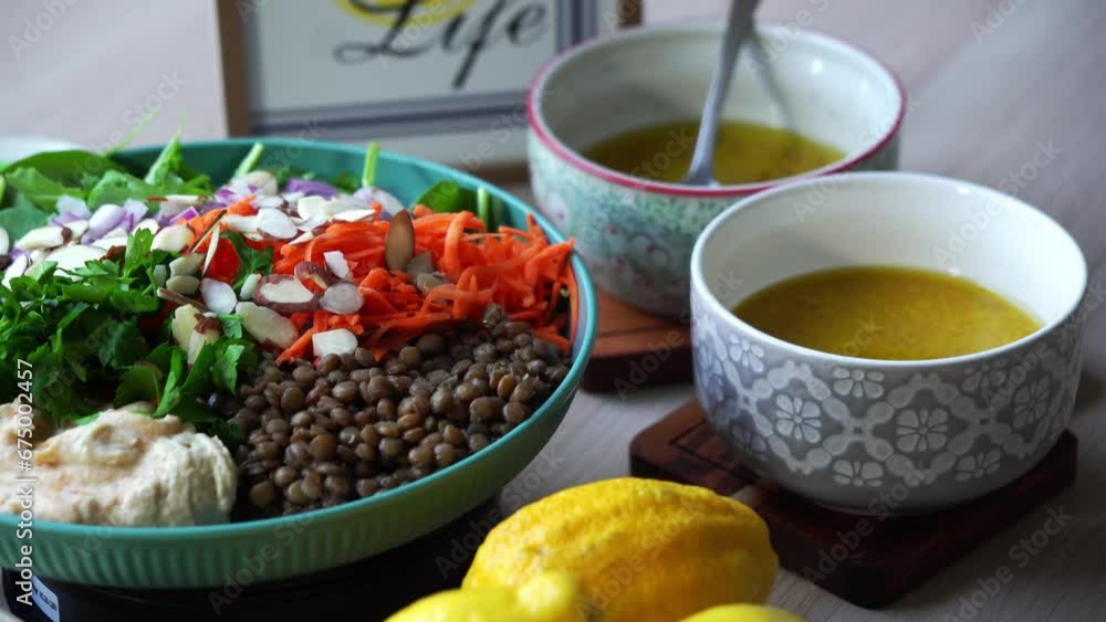 plate of salad on rotating platform lentils sliced almonds carrots spinach cilantro dressing and lemons plate of salad on rotating platform lentils sliced almonds carrots spinach cilantro dressing and lemons