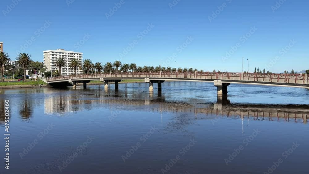 Bridge crossing over the river lined with palm trees and high rise apartments on a sunny day Bridge crossing over the river lined with palm trees and high rise apartments on a sunny day