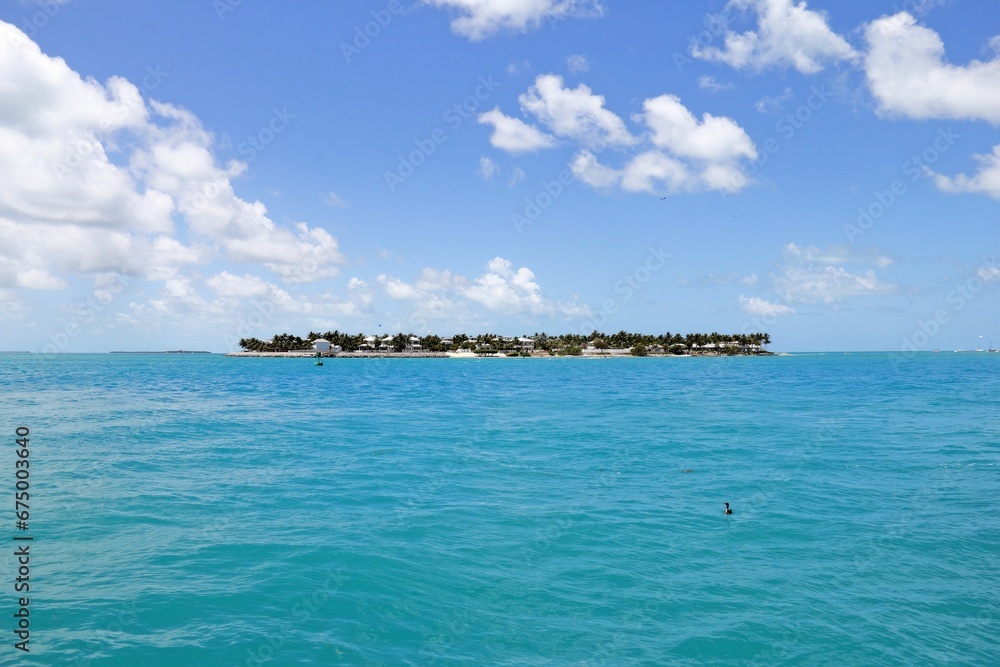Scenic view of the ocean, with a blue sky and island in the background. Miami, Florida, USA. Scenic view of the ocean, with a blue sky and island in the background. Miami, Florida, USA.