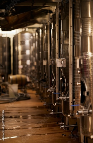 the inside of a wine brewery with many racks and a small tank