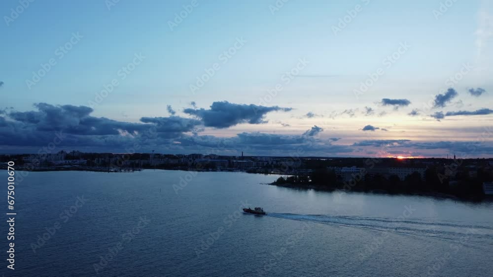 Fishing vessel motors on sea as sun sets over deep blue Helsinki, FIN Fishing vessel motors on sea as sun sets over deep blue Helsinki, FIN