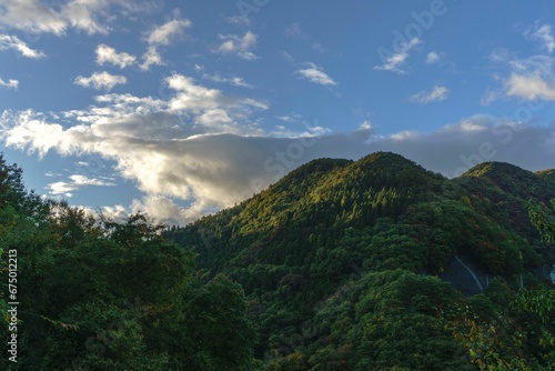 Scenic landscape with green hills and a blue sky with fluffy clouds. Akagiyama, Japan © Wirestock