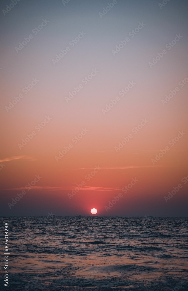 Breathtaking sunrise over a tranquil ocean, illuminated by a stunning golden hue