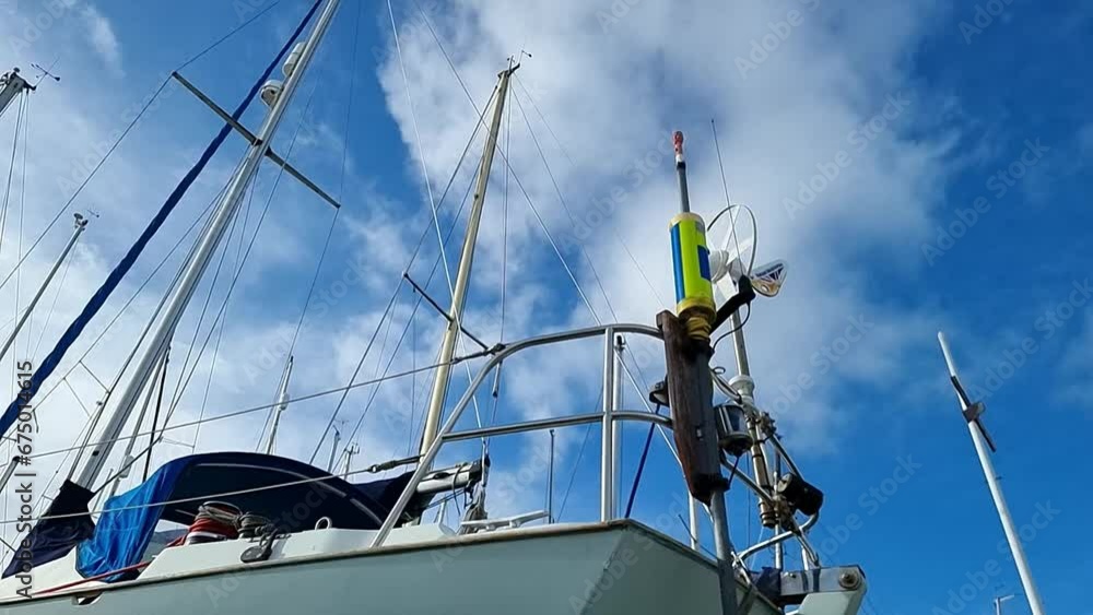 Looking up at yacht masts with spinning wind turbine generator mounted on rear deck railings Looking up at yacht masts with spinning wind turbine generator mounted on rear deck railings
