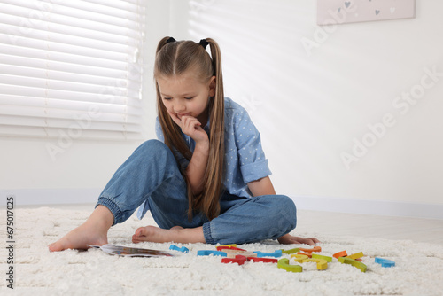 Motor skills development. Girl playing with colorful wooden arcs indoors