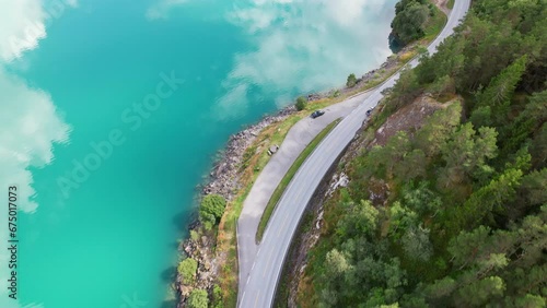 A winding road and amazing sky reflections in the Oppstrynsvatnet lake photo