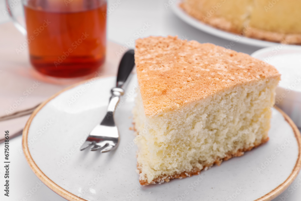 Piece of tasty sponge cake on white table, closeup Piece of tasty sponge cake on white table, closeup