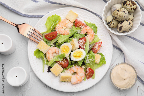 Delicious Caesar salad with shrimps and fork served on white textured table, flat lay