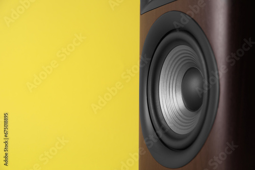 One wooden sound speaker on yellow background, closeup. Space for text photo