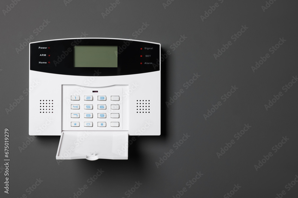 Home security alarm system on gray wall, space for text Home security alarm system on gray wall, space for text