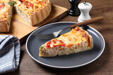 Tasty quiche with chicken, vegetables and cheese served on wooden table, closeup