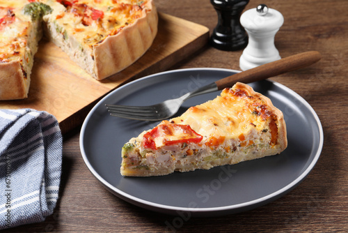 Tasty quiche with chicken  vegetables and cheese served on wooden table  closeup