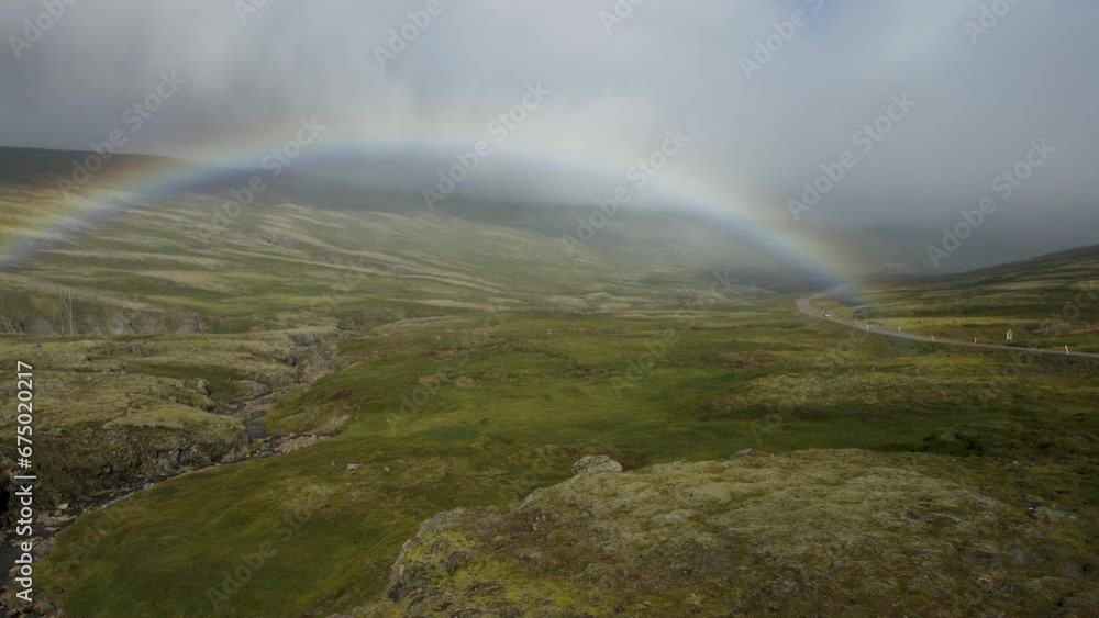 Unveil a surprise rainbow emerging through the fog atop an Icelandic mountain, post-rainstorm — a mystical moment in crisp 4K, captured by drone. Unveil a surprise rainbow emerging through the fog atop an Icelandic mountain, post-rainstorm — a mystical moment in crisp 4K, captured by drone.