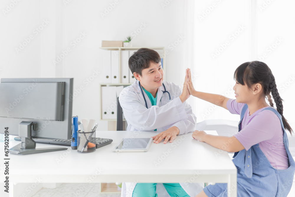 Asian doctor talk with children patient about disease symptom, doctor use hand touch on hand of patient, they hi five together, children health check up, happiness hospital Asian doctor talk with children patient about disease symptom, doctor use hand touch on hand of patient, they hi five together, children health check up, happiness hospital