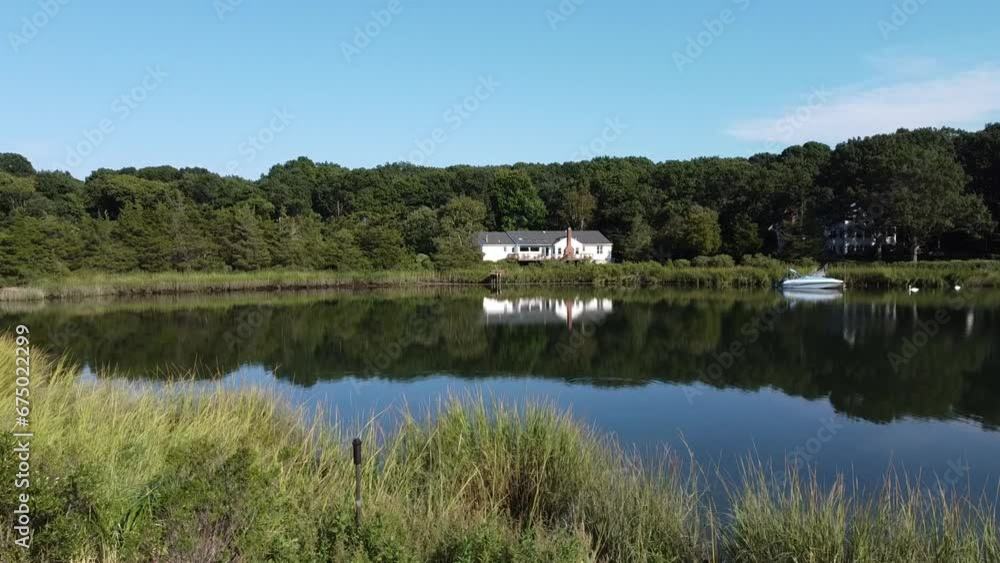 Beautiful view of a pond reflecting trees in a forest and a house Beautiful view of a pond reflecting trees in a forest and a house
